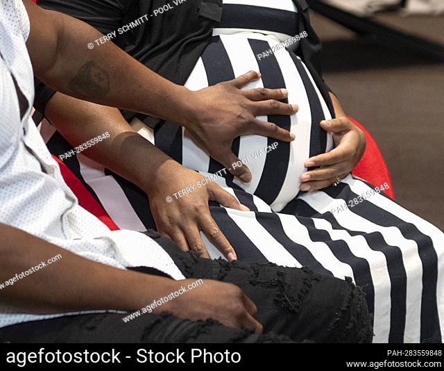 A father touches a pregnant belly as Vice President Kamala Harris speaks with doctors, nurses, doulas and healthcare professionals during a tour of the...