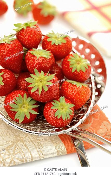 Fresh strawberries on a draining spoon