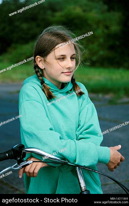 Girl leaning on her bicycle handlebars on Langeoog, Germany