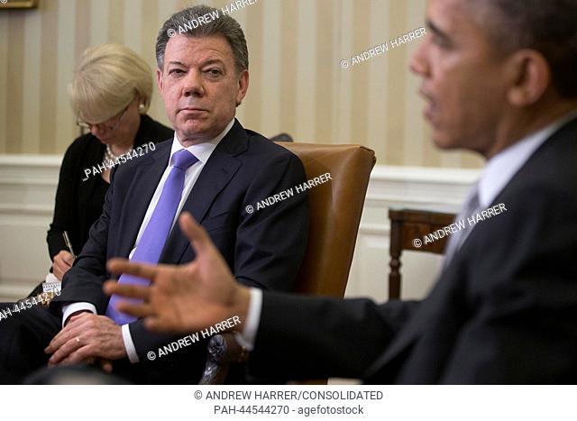 President Juan Manuel Santos of Colombia, left, listens as United States President Barack Obama speaks in the Oval Office of the White House in Washington, D