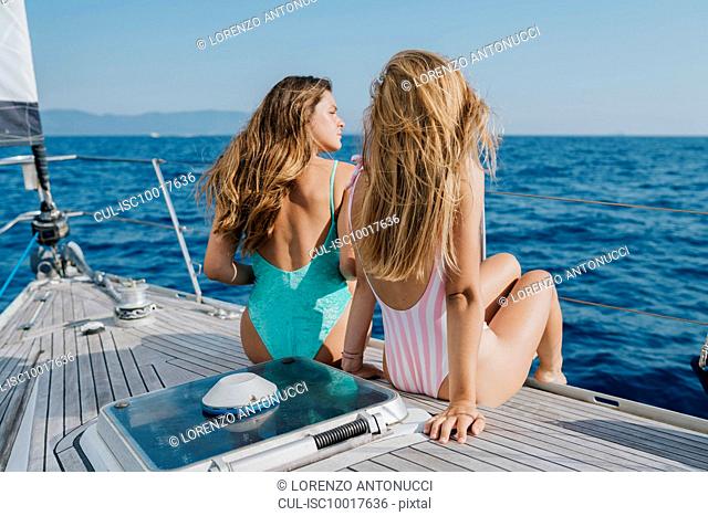 Friends relaxing on deck of sailboat, Italy