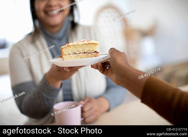 Close up daughter serving cake to mother