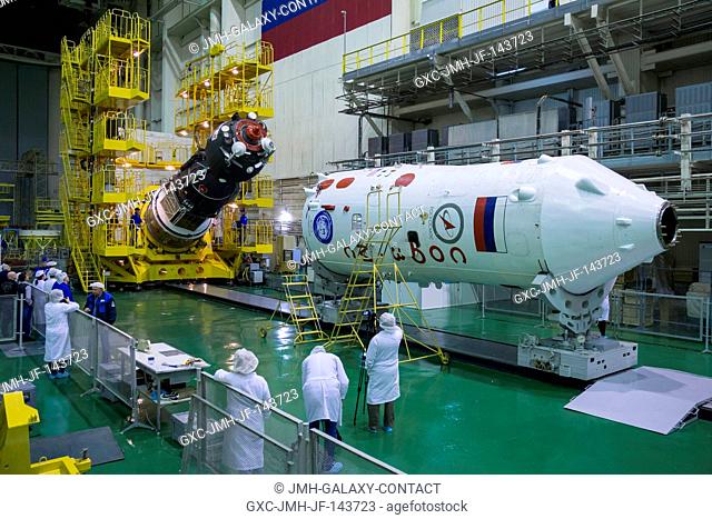 The Soyuz MS-02 spacecraft is seen as it is rotated from a vertical to a horizontal position in preparation for being encapsulated in its fairing on Thursday