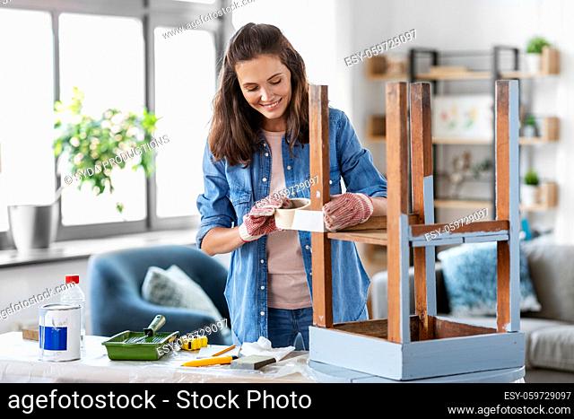woman sticking masking tape to table for repaint