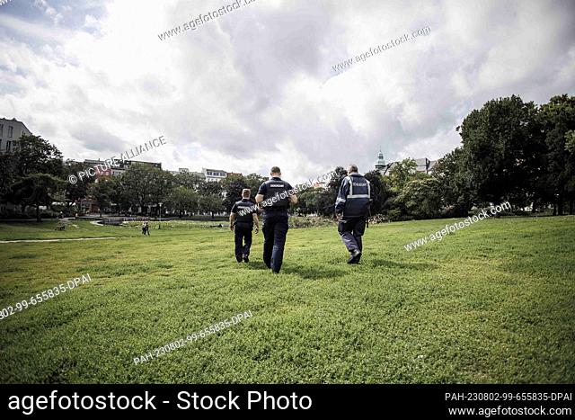 PRODUCTION - 01 August 2023, Berlin: Employees of the public order office patrol the meadow in Weinbergspark. The inspections by the public order office are...