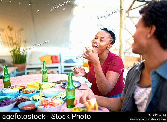 Young woman enjoying taco lunch at patio table