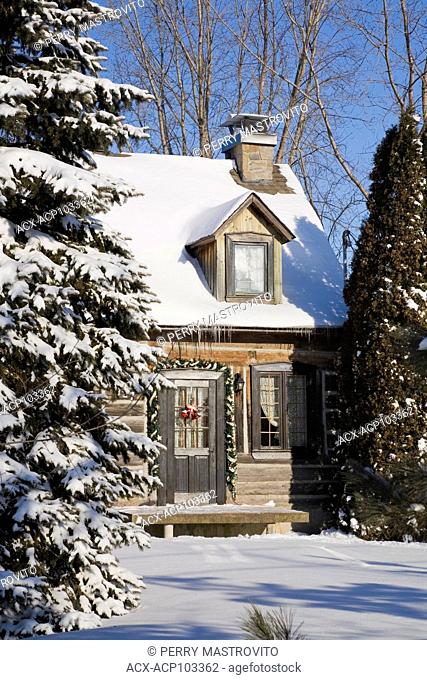 Residential cottage style reconstructed (1982) log home in winter with Christmas decorations, Quebec, Canada. This image is property released for calendar, book