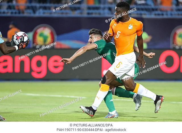 11 July 2019, Egypt, Suez: Cote d'Ivoire's Wilfried Kanon (R) and Algeria's Baghdad Bounedjah battle for the ball during the 2019 Africa Cup of Nations quarter...