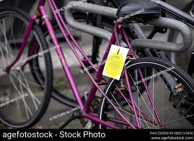 03 March 2022, Berlin: Several scrap bicycles stand at the Wedding S-Bahn and U-Bahn station with a sign for removal by the Ordnungsamt Mitte