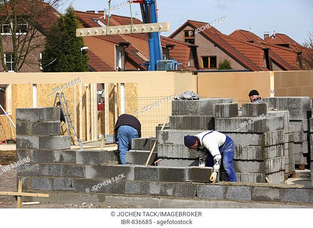 Construction site of a one family house made of stone and concrete, behind it a wooden house, passive house, Recklinghausen, North Rhine-Westphalia, Germany