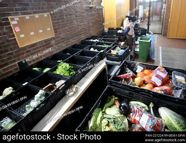 13 December 2022, North Rhine-Westphalia, Oberhausen: An employee of the Oberhausen food bank sorts fruit and vegetables in the nave of a former church