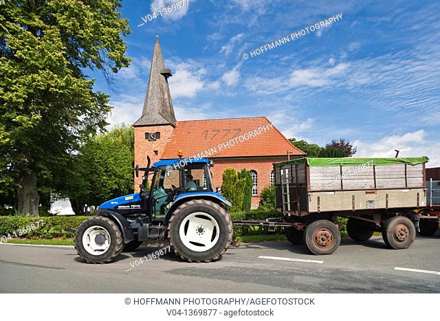 The historic brick church of Staffhorst and a blue tractor, Lower Saxony, Germany, Europe