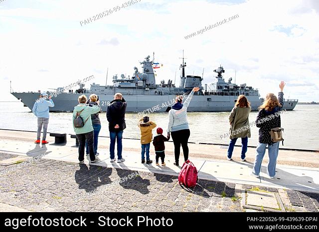 26 May 2022, Lower Saxony, Wilhelmshaven: Members of the crew wave goodbye as the Navy frigate ""Mecklenburg-Vorpommern"" leaves the harbor at the naval base