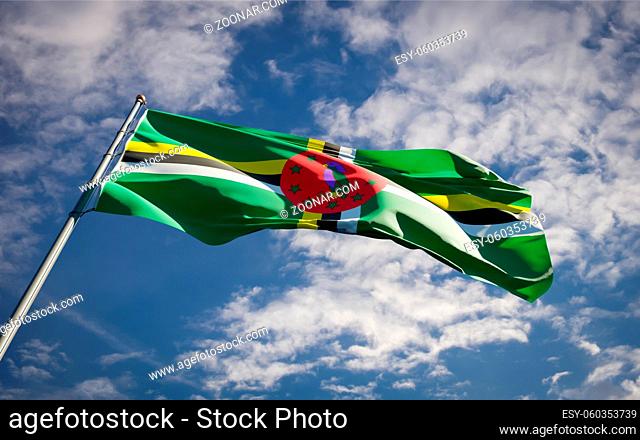 Beautiful national state flag of Dominica fluttering at sky background. Low angle close-up Kir Dominica ibati flag 3D artwork