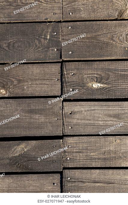 photographed close-up part of the wall made of planks, visible metal nails for attaching construction materials