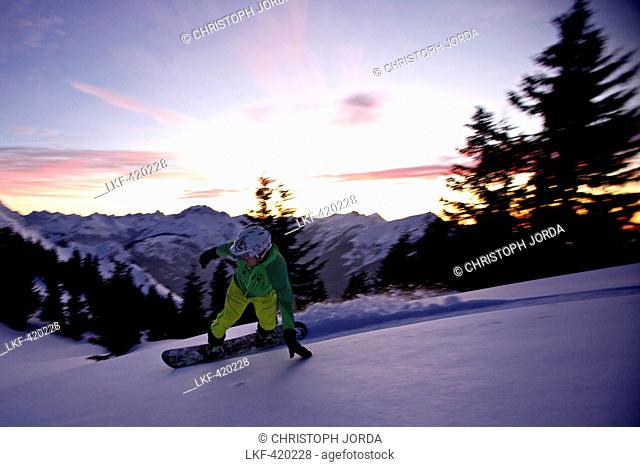 Snowboarder making a turn in fresh snow, Hahnenkamm, Tyrol, Austria