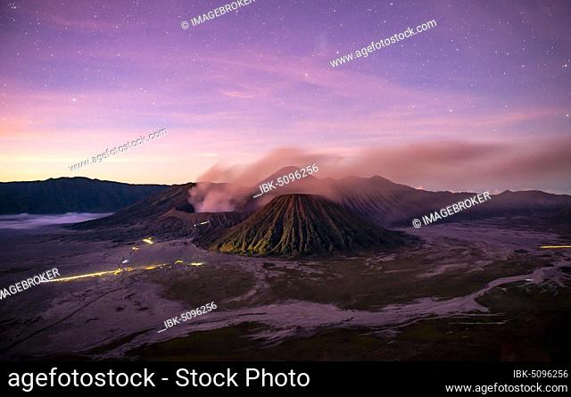 Volcanic landscape at sunrise with starry sky, smoking volcano Gunung Bromo, with Mt. Batok, Mt. Kursi, Mt. Gunung Semeru, National Park Bromo-Tengger-Semeru