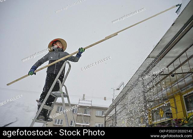 A Vietnamese shopkeeper removes snow from his shop in Kostelec u Jihlavy, Jihlava region, Czech Republic, December 2, 2023. (CTK Photo/Lubos Pavlicek)