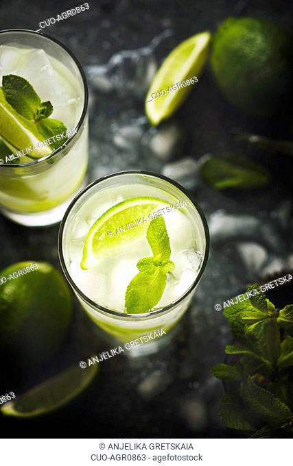 Mojito cocktail with lime and mint in glass on a stone table