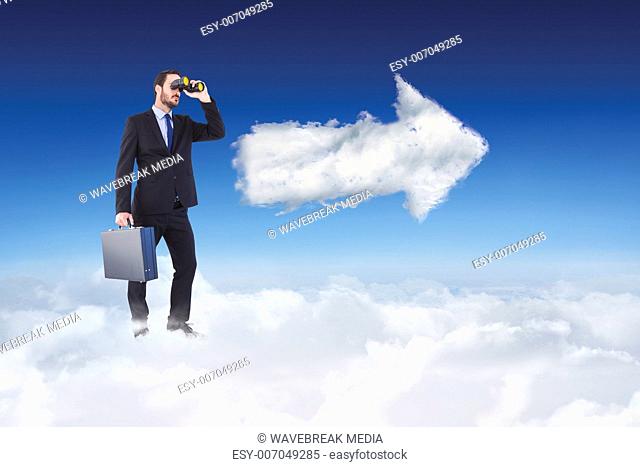 Composite image of businessman looking through binoculars holding briefcase