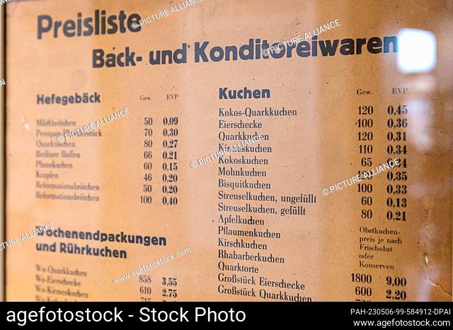 06 May 2023, Brandenburg, Lübbenau: Behind glass hangs a price list for baked goods and confectionery. Food was subsidized in the GDR and was very cheap