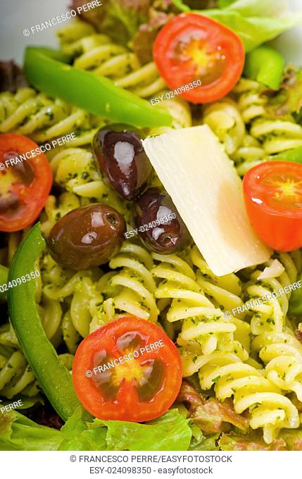 fresh healthy homemade italian fusilli pasta salad with parmesan cheese, pachino cherry tomatoes, black olives and mix vegetables