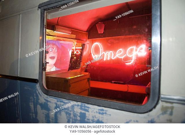 Neon omega sign seen through caravan window