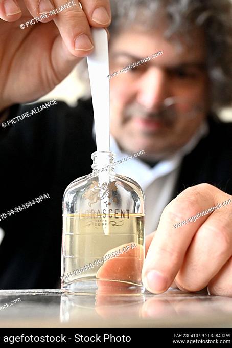 PRODUCTION - 03 April 2023, Baden-Württemberg, Karlsruhe: Perfumer Roland Tentunian takes a scent sample from a bottle during a recipe development for a perfume...