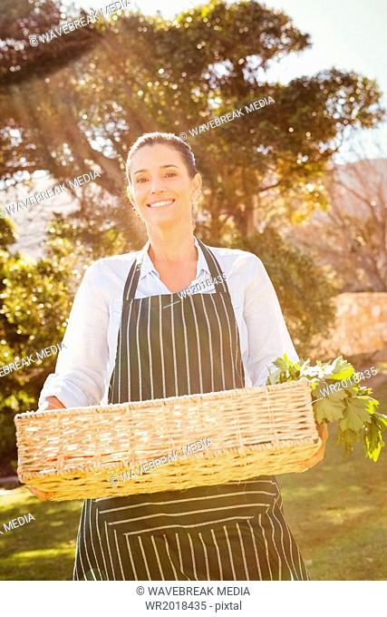 Smiling farmer woman holding a vegetable basket
