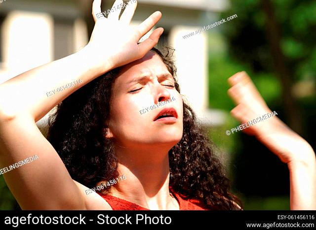 Overwhelmed woman suffering heat stroke a sunny day in a park