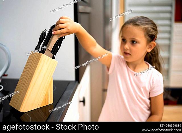 Child Hand Reaching For Knife. Kitchen Safety Risk