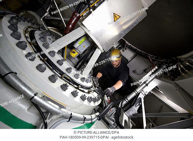24 April 2018, Germany, Driedorf: Controller Christoph Lober checking the hub of a wind turbine. The machines, rotor blades and the supporting structure (tower...