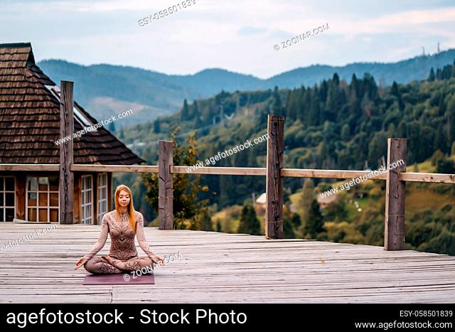 Woman practices yoga in mornin, fresh air