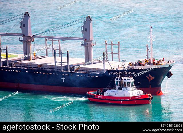 NAPIER, NEW ZEALAND -SEPTEMBER 30, 2017: Tug boats guide a shipping container into the Port of Napier in New Zealand
