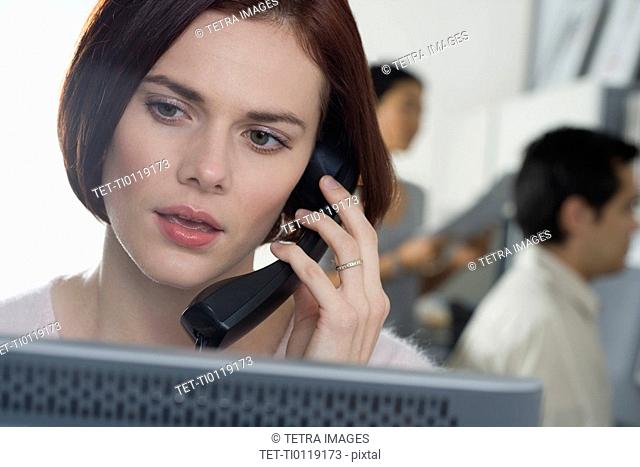 Woman talking on phone in office