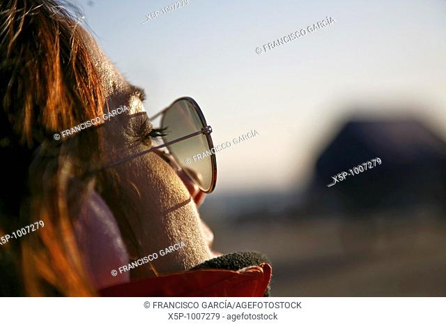 Mujer sentada y relajada tomando los ultimos rayos de sol del dia