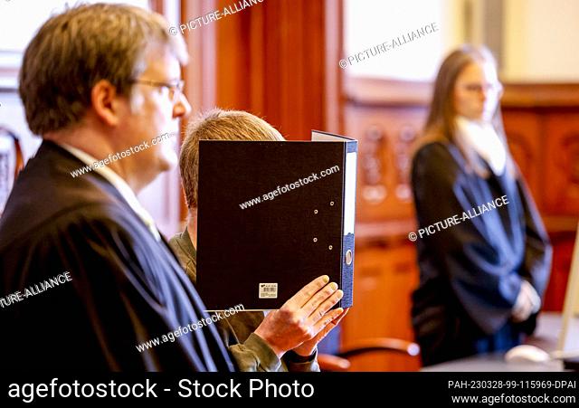 28 March 2023, Schleswig-Holstein, Flensburg: The 54-year-old accused alleged alternative practitioner waits next to his lawyer Volker Ramge (l) for the trial...