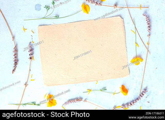 Brown craft paper with flowers, a stationery mockup for a birthday card or wedding invitation, shot from above with a place for text
