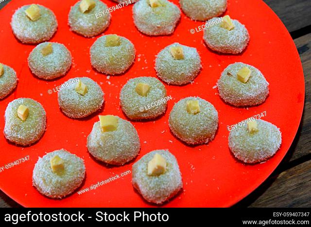 Homemade milk sweets called beijinho served on a red tray. Sweets for birthday party. Delicious desserts. Decorated kisses and served on a colorful plate