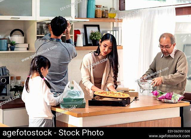 Happy asian multigenerational family of dad mom daughter girl and grandfather setting up dining table before meal. Asian happy family doing domestic life...