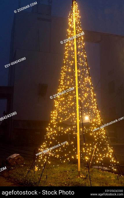grosser LED-Lichterkette beleuchteter Weihnachtsbaum als Aussendekoration - Christbaum