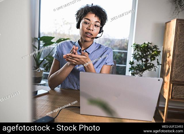 Woman having video conference via laptop at home