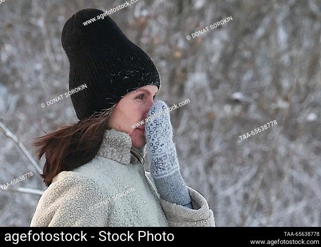 RUSSIA, YEKATERINBURG - DECEMBER 11, 2023: A woman walks by the Iset River on a frosty winter day; the air temperature has dropped to -29 degrees Celsius