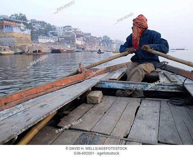 A boat man rows his boat to show visitors life along the holy river Ganges, an important pilgrimge site for Hindu's, in Varanasi, Uttar Pradesh, India