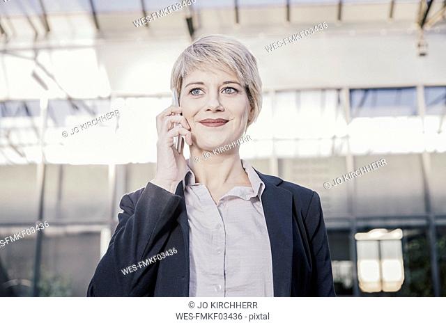 Portrait of smiling blond businesswoman on the phone