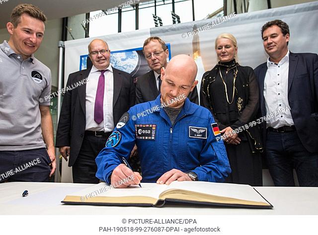 18 May 2019, Baden-Wuerttemberg, Künzelsau: Alexander Gerst (M), astronaut, signs the Golden Book of the city in the town hall