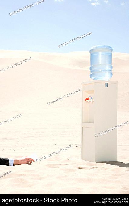 Person reaching for water cooler in desert