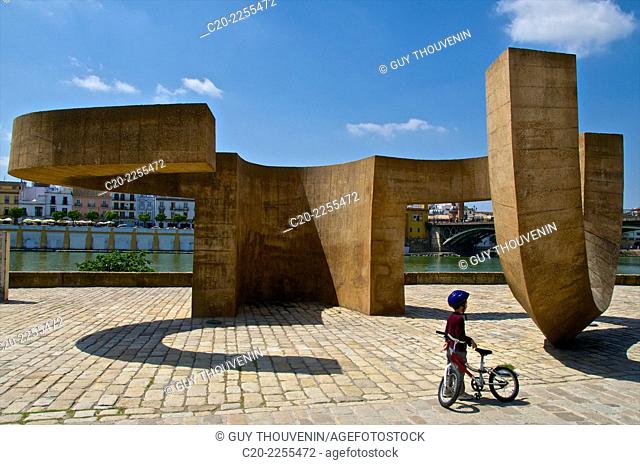 Child and bike with Monument La Tolerantia by Eduardo Chillida, on paseo de Cristobal Colon, Sevilla, Andalusia, Spain