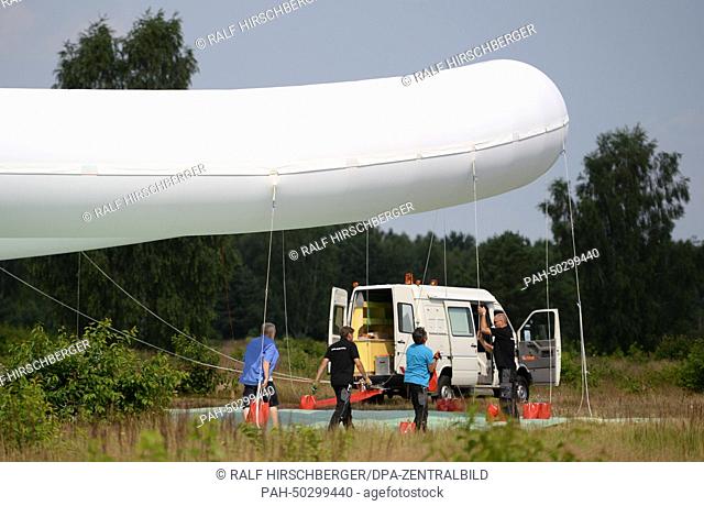 Employees from the Federal Institute for Geosciences and Natural Resources stands under a 22 meter wide mobile measuring balloon at the military training field...