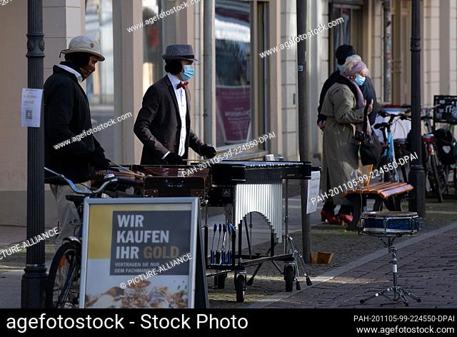 05 November 2020, Brandenburg, Potsdam: Street musicians play with mouth and nose protection in Potsdamer Brandenburger Straße. Photo: Paul Zinken/dpa